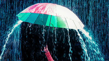 Holding an umbrella in a rainstorm